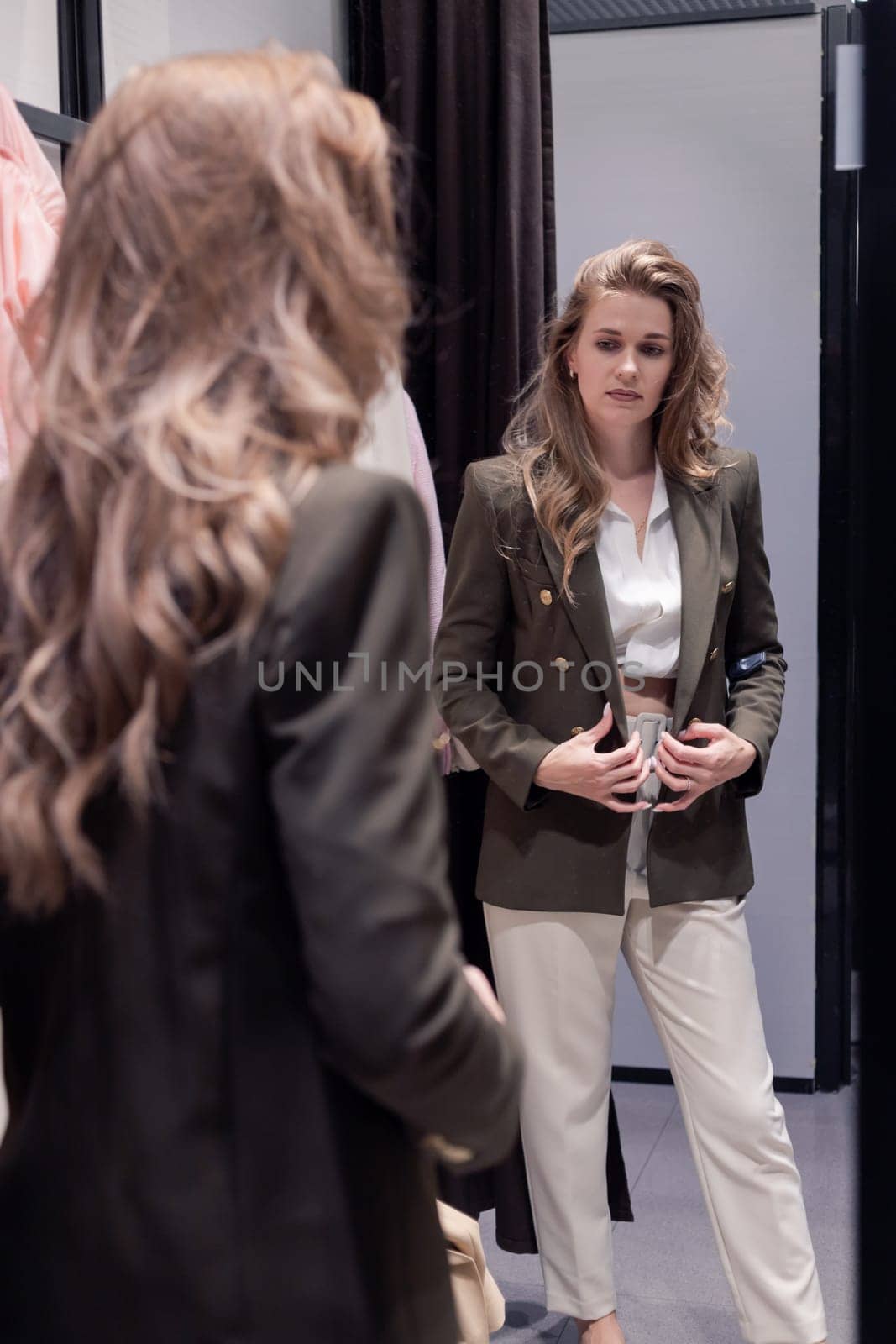 Woman in dressing room fits new formal look. Candid photo