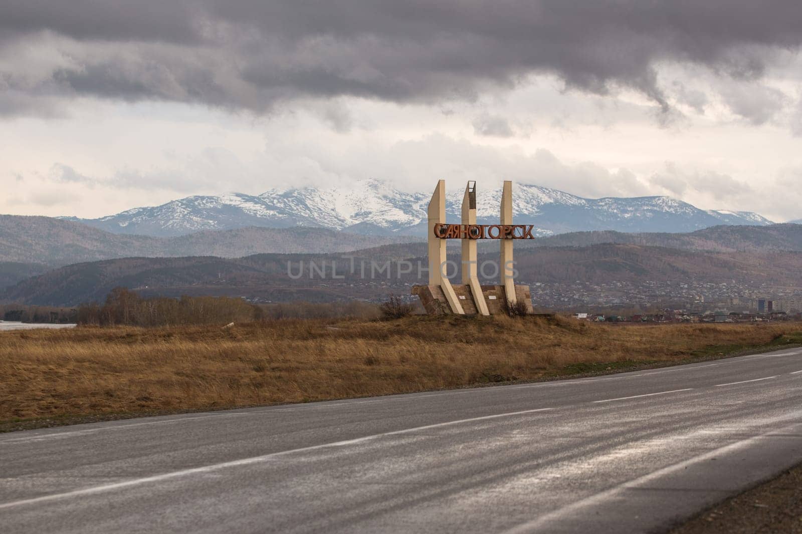 Sayanogorsk, Khakassia, Russia - a road sign-monument stella at the entrance to the city. Soviet vintage road decoration. Translation: Sayanogorsk.