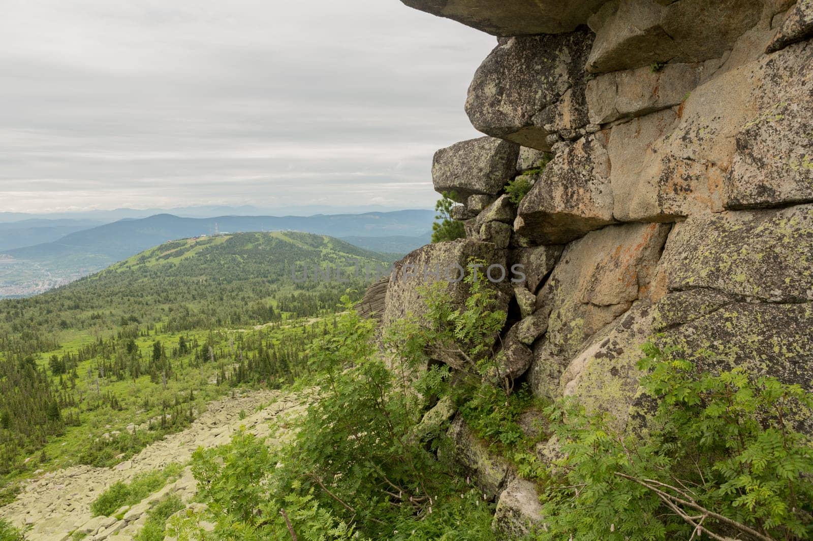 large kurum stones lie in the forest in the mountains, stones covered with moss, against the background of the forest, mountain landscape, high in the mountains..