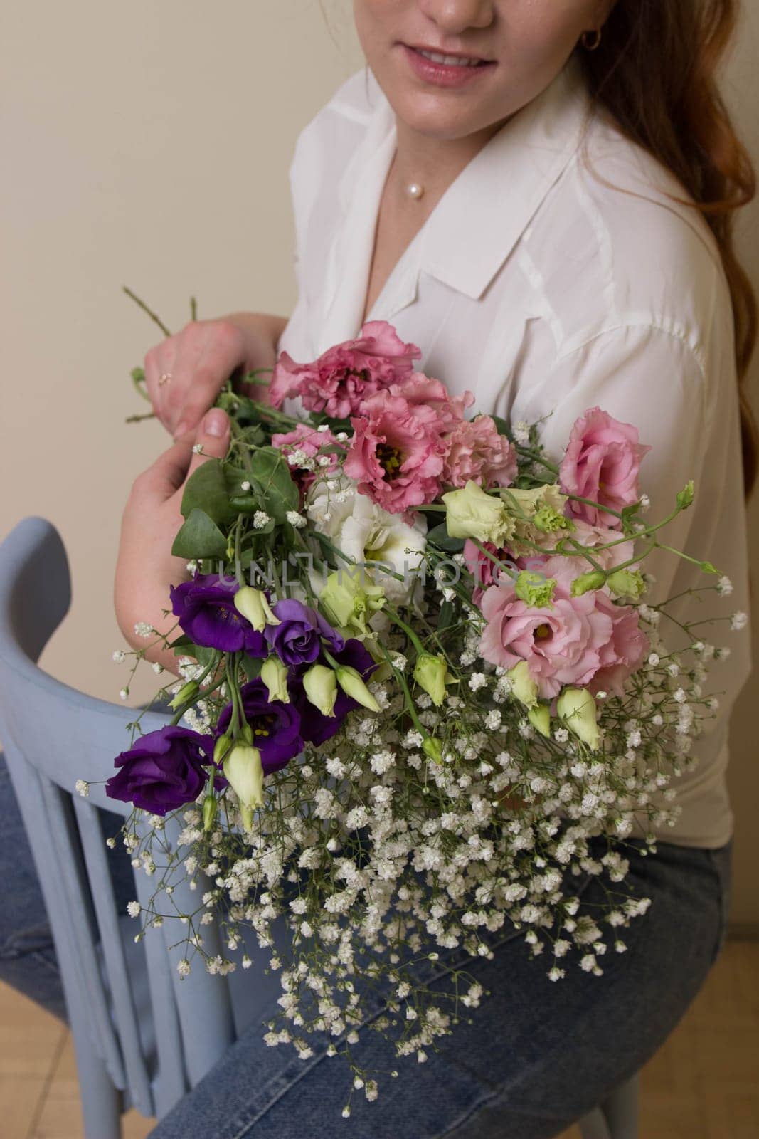 a girl or a woman holds a bouquet of small flowers.