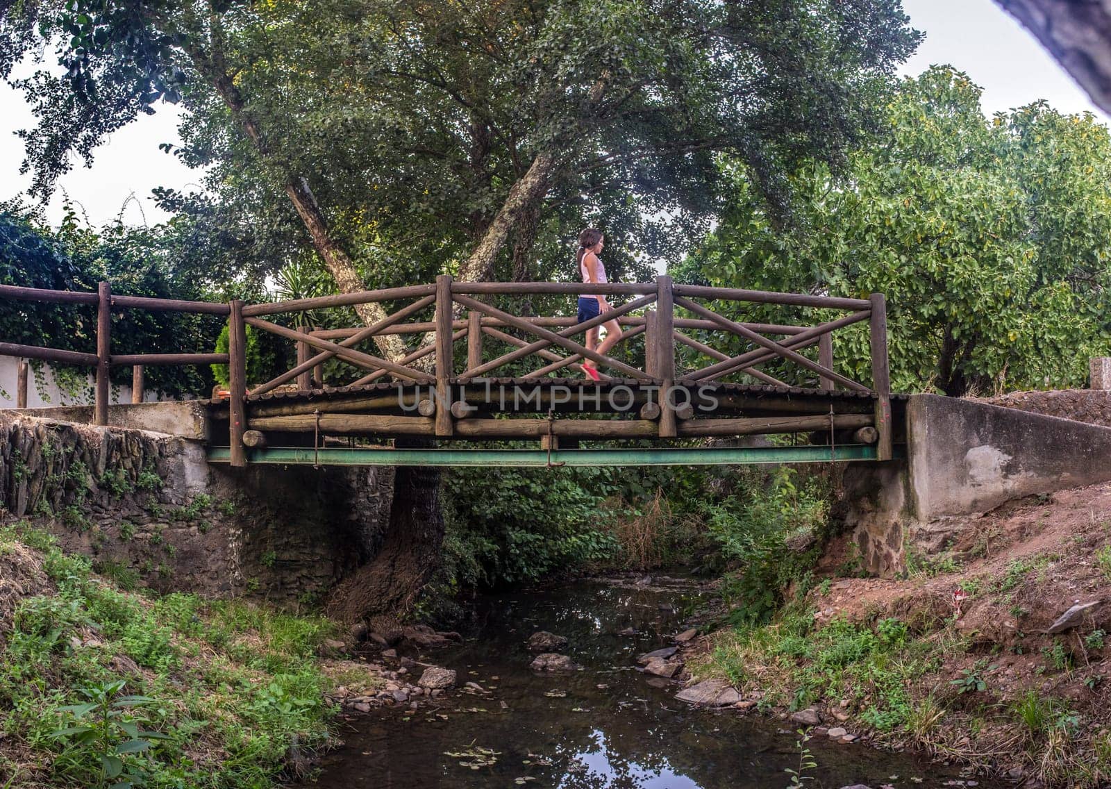 Child girl crossing The world shortest international bridge of El Marco. La Codosera district, Extremadura, Spain