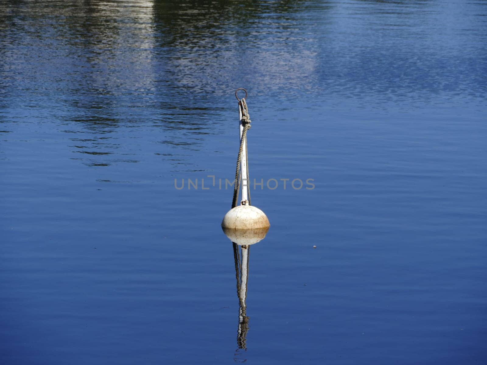 white steel buoy on blue sea surface