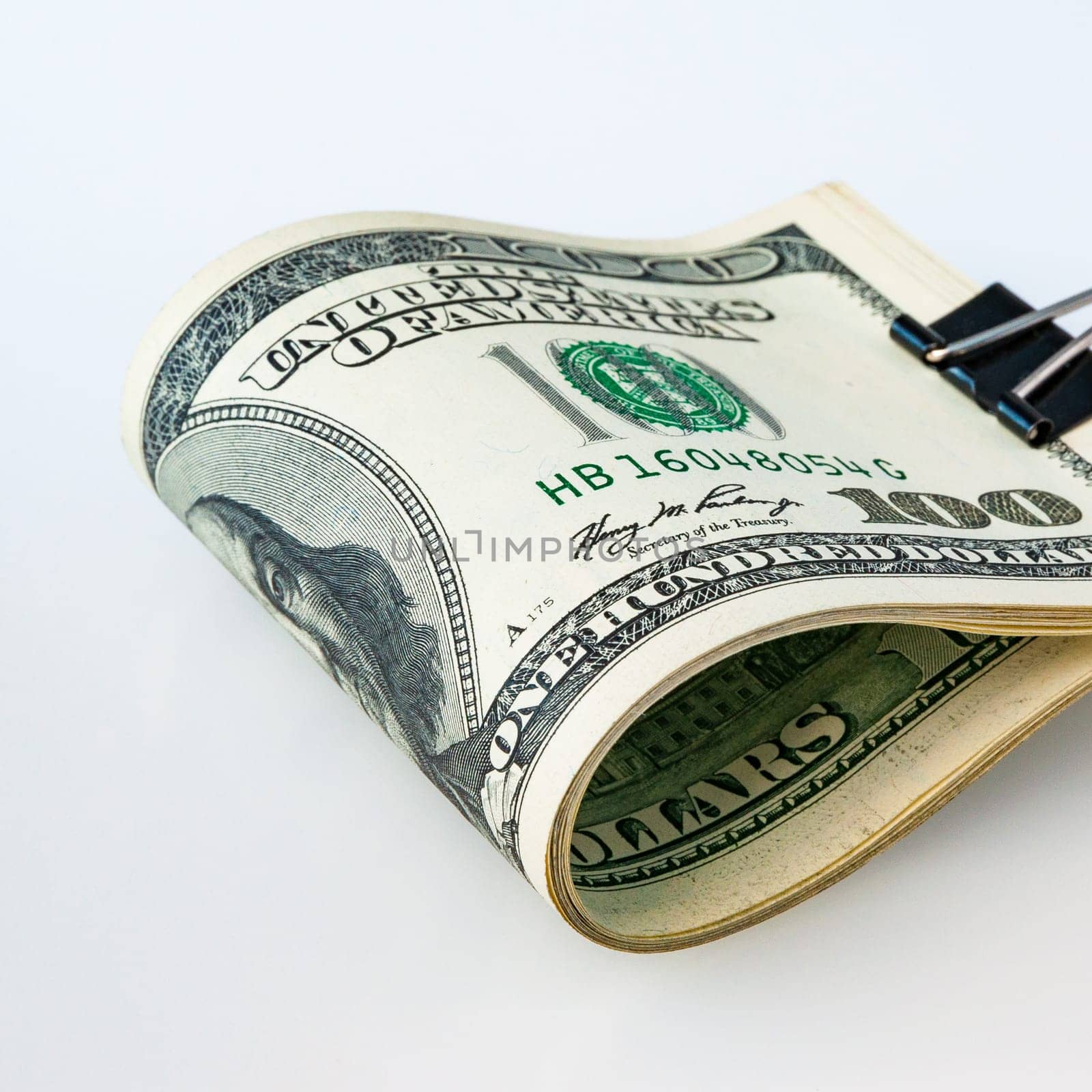 A stack of packaged dollars on a white background. One hundred American dollar bills. The pile of dollars is isolated with a shadow. A big wad of dollars. Place for logo, lettering, layout, layout.