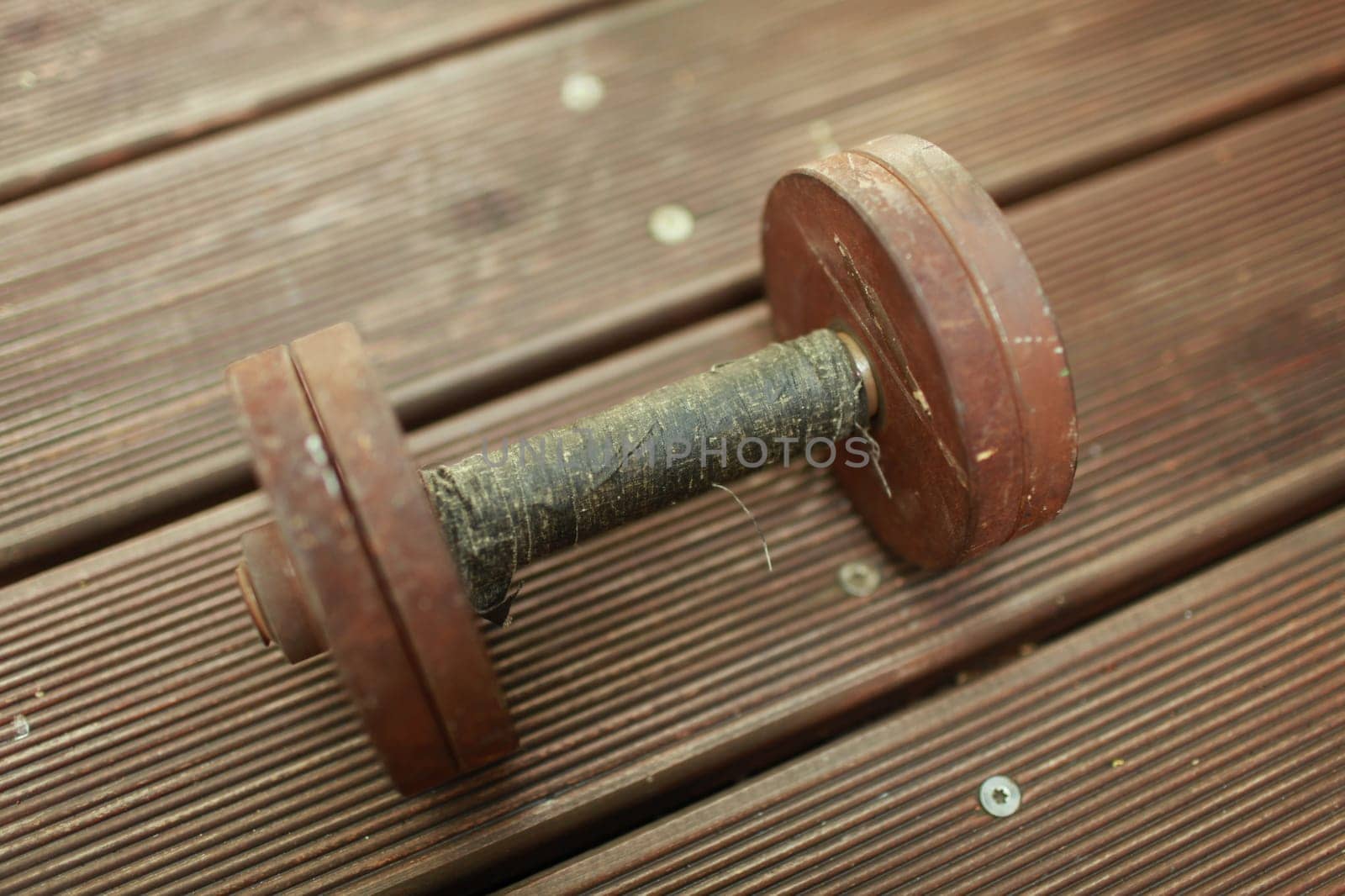 old heavy steel dumbbell, handle rewound with black duct tape close-up