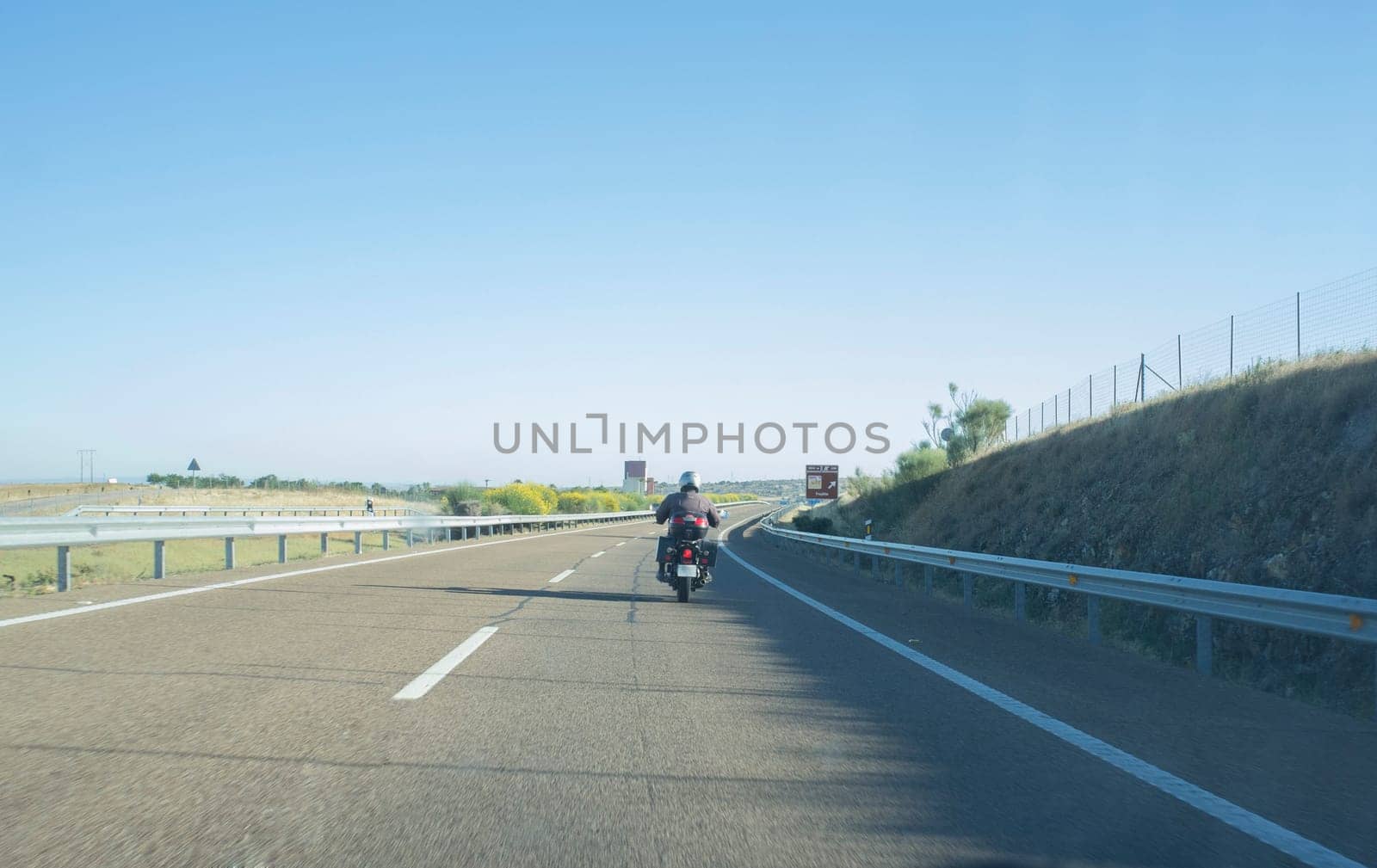 Driving behind a biker by autovia. Driving scene