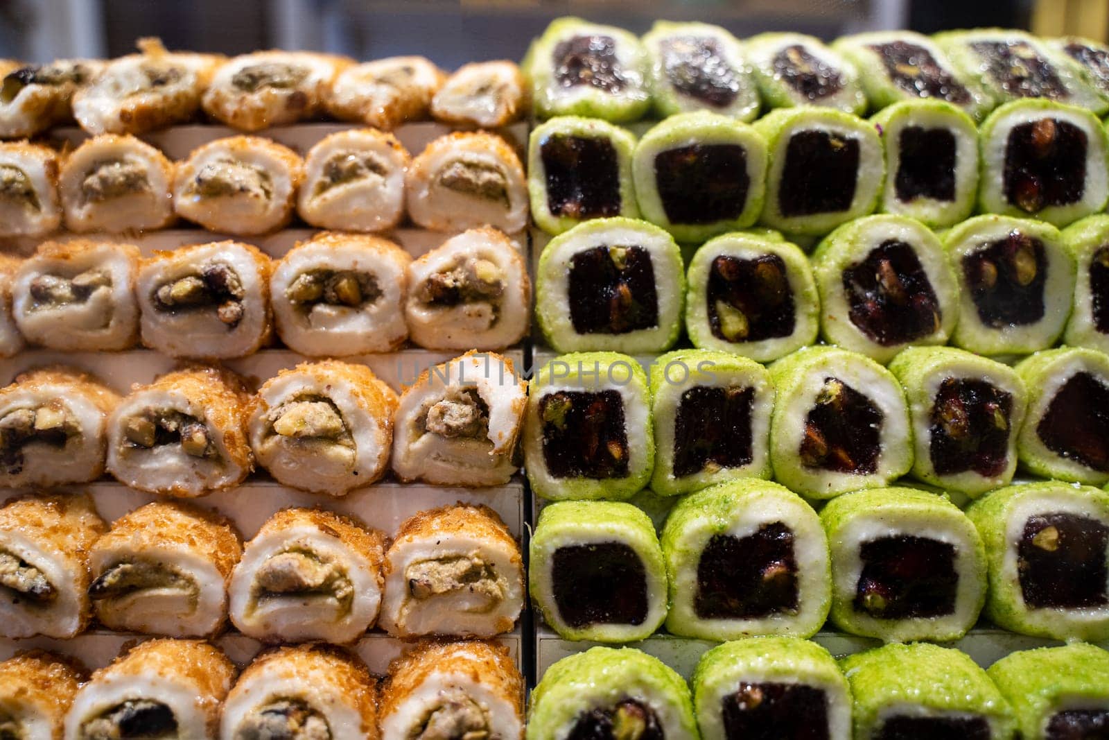 rows of assorted Turkish delight sweets desserts with dried fruits lined up in the store window
