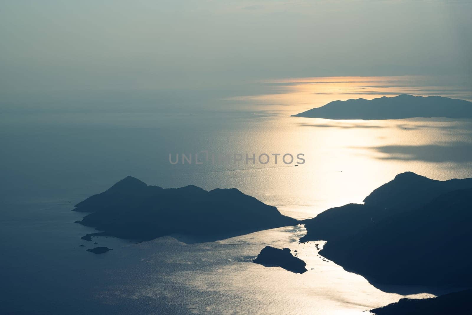 beautiful aerial panorama from the Babadag peak of high mountains rising up over the Mediterranean sea at sunset near Oludeniz Blue Lagoon coast in Turkey during summer