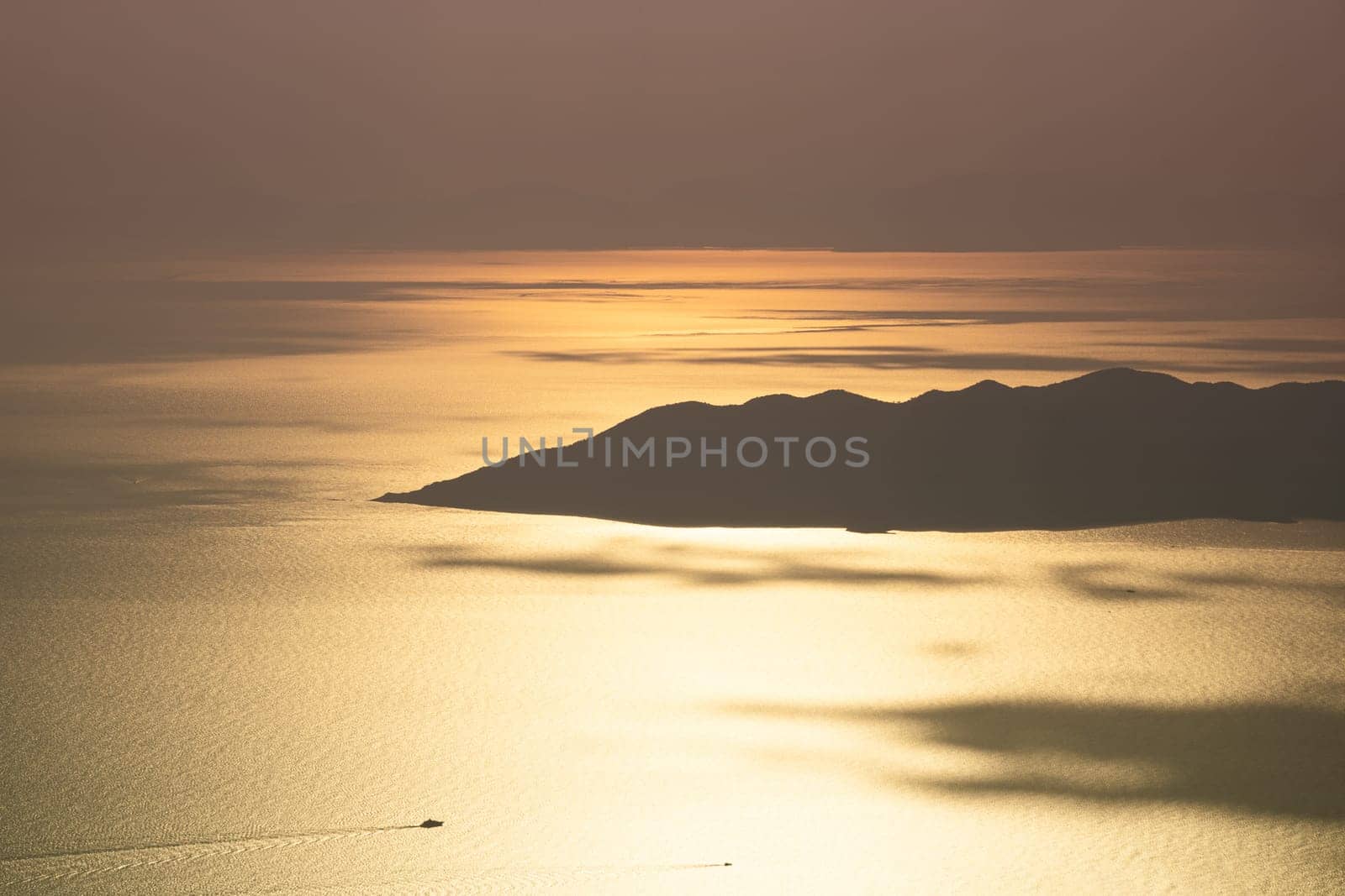beautiful aerial panorama from the Babadag peak of high mountains rising up over the Mediterranean sea at sunset near Oludeniz Blue Lagoon coast in Turkey during summer