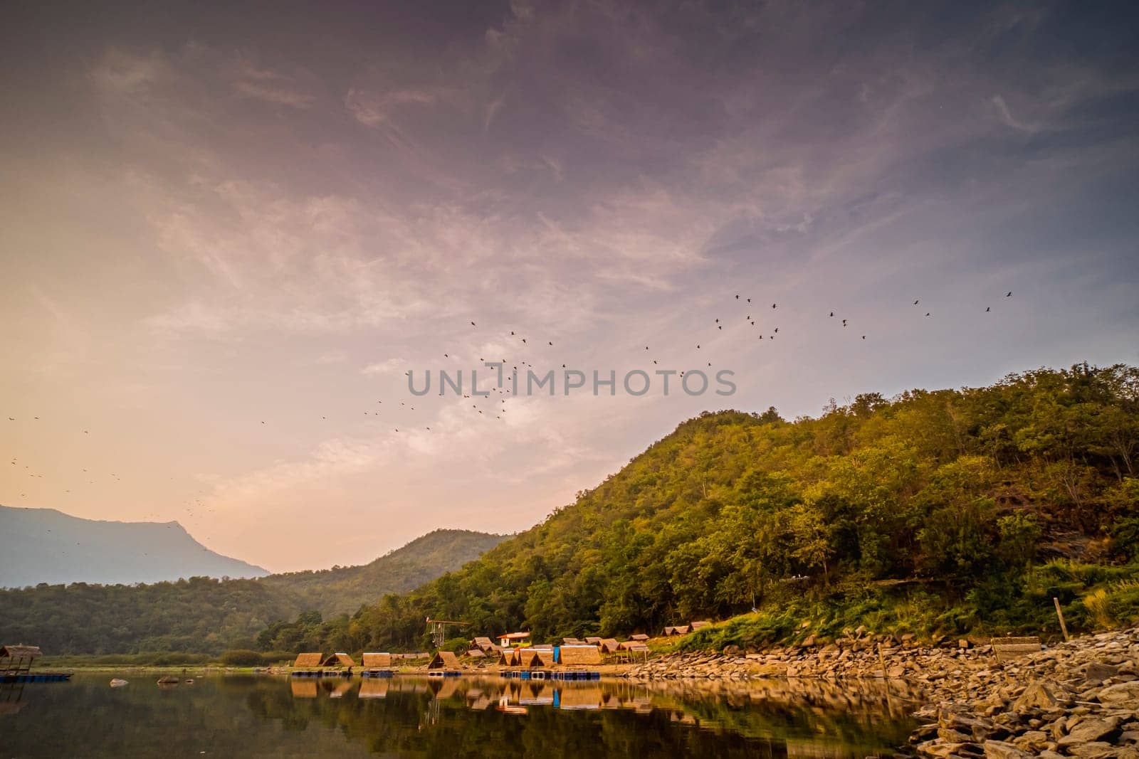 Panorama View of tropical lake and mountains. Small bamboo traditional cottage next the lake in Sukhothai Thailand