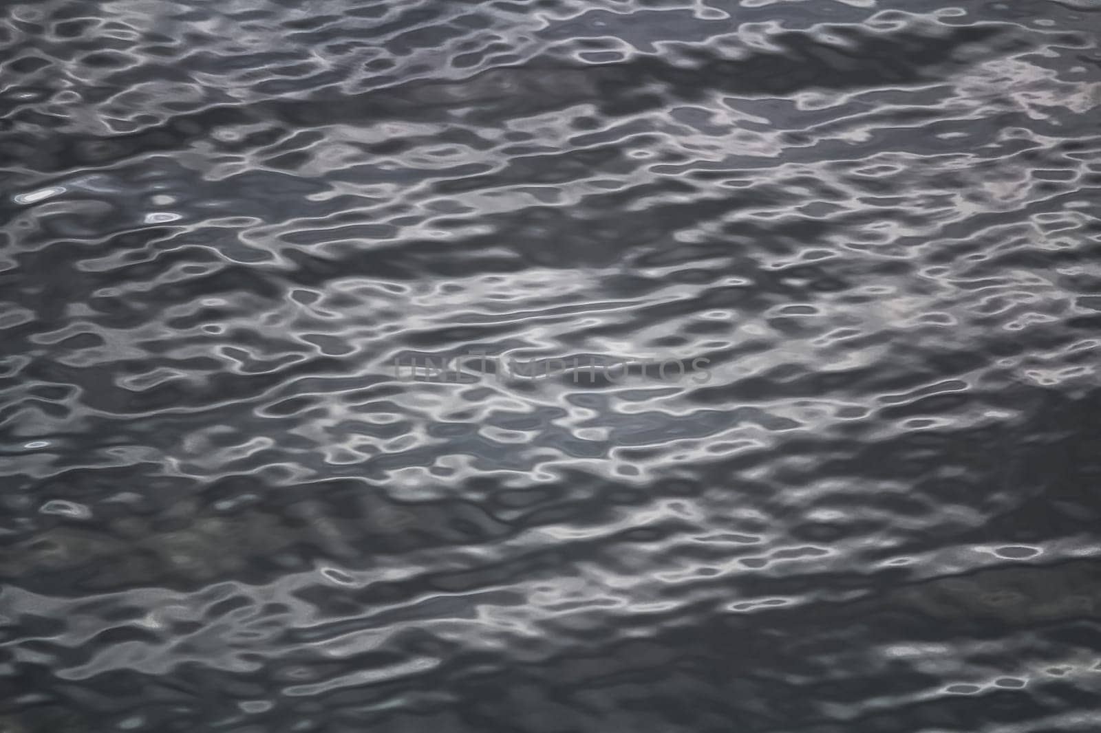 An abstract background of grey water ripples.