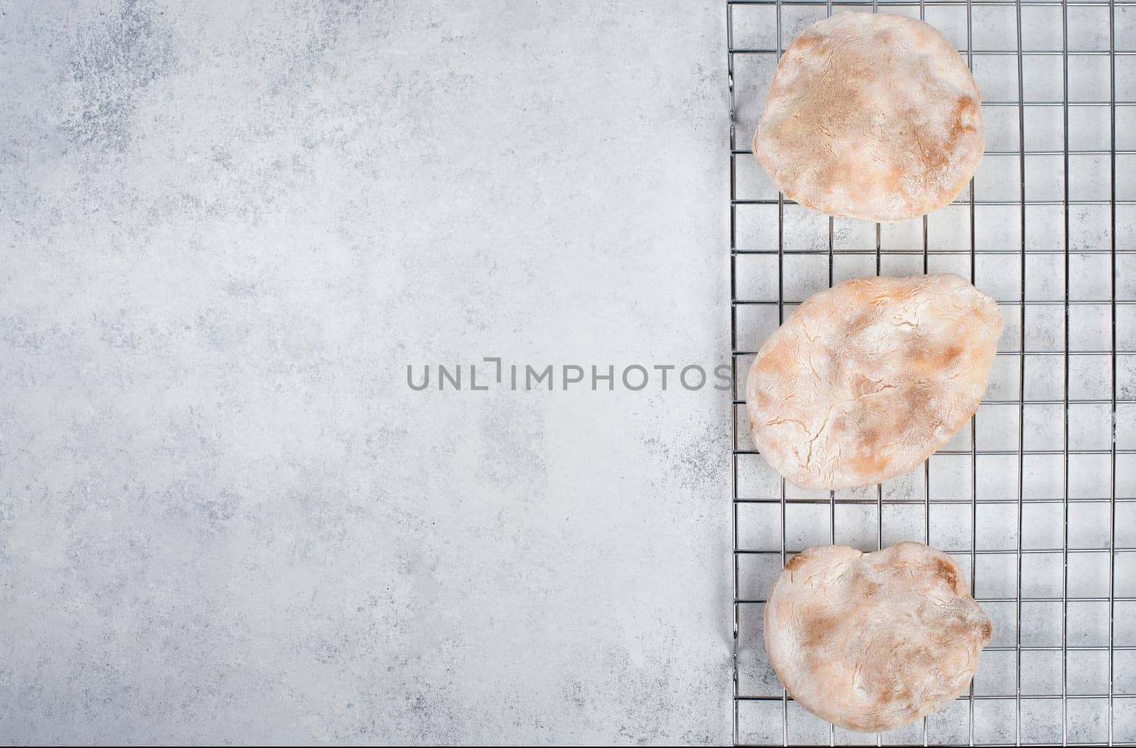 Fresh baked pita bread on a colling grid, empty copy space for text