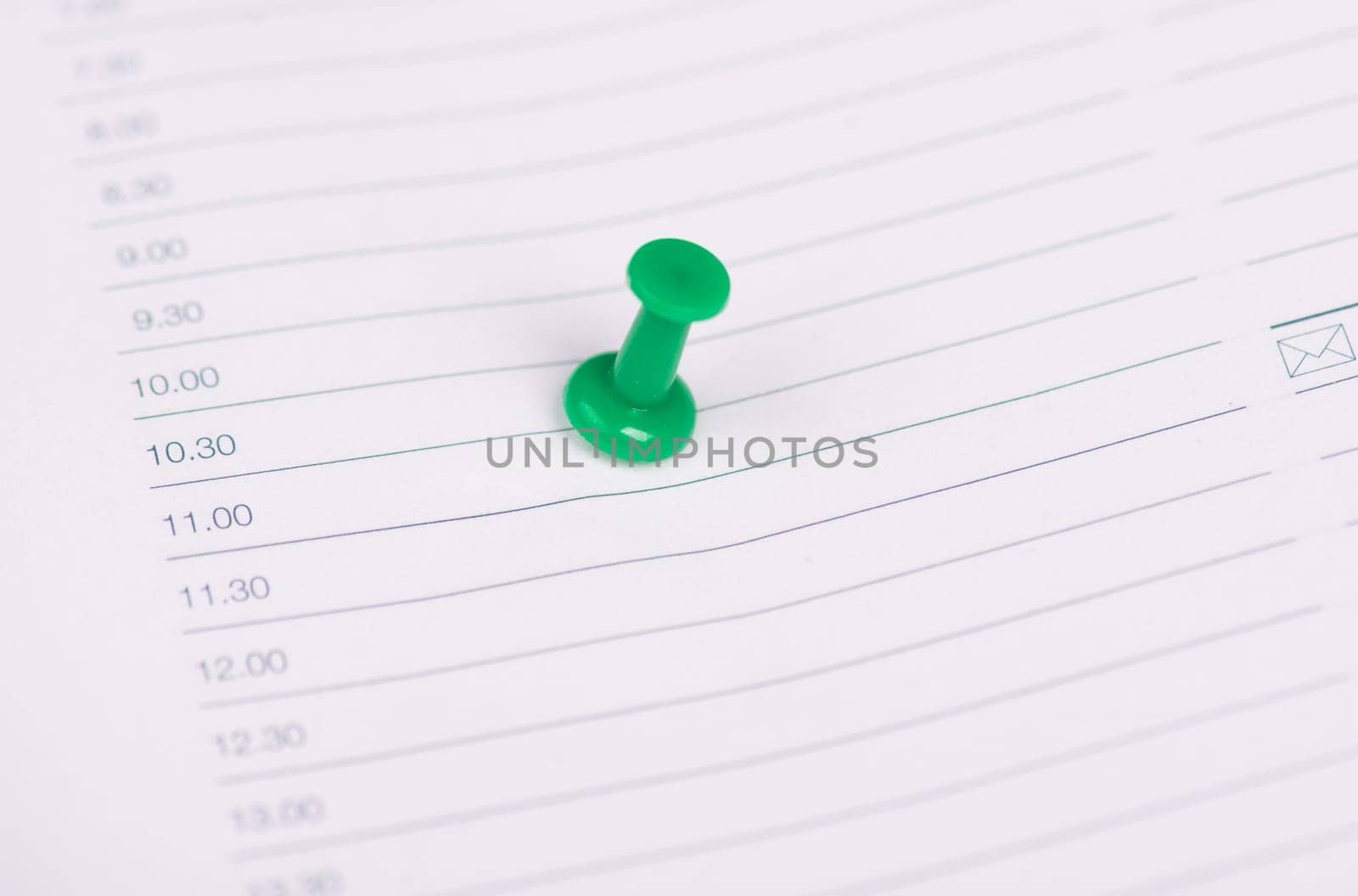 Green pin needle in an empty calendar page, saving the date