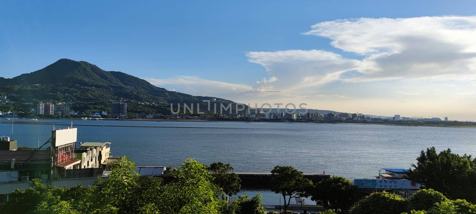 Tamsui, NEW TAIPEI CITY, TAIWAN - Sep 8, 2021 - City Tamsui Bali District in Taipei, Taiwan reflecting in the Tamsui River at nice day