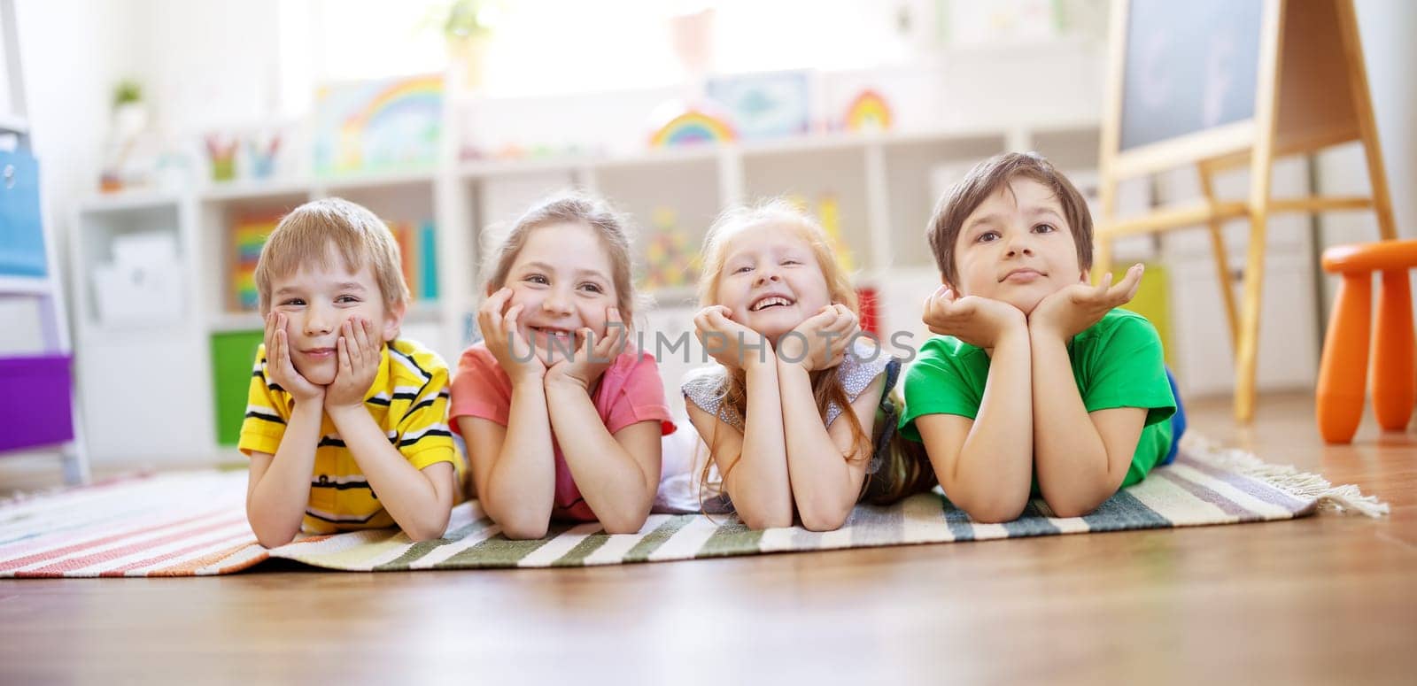 Group of children lying on the floor and looking in the camera. Concept of relationship, friendship and education.