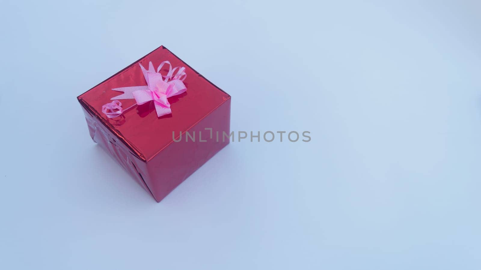 Red Gift box with Ribbon in white background. Copy Space