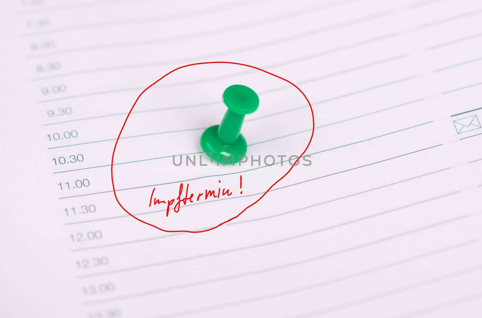 The german words for vaccination appointment is standing on a calendar page with a pin needle