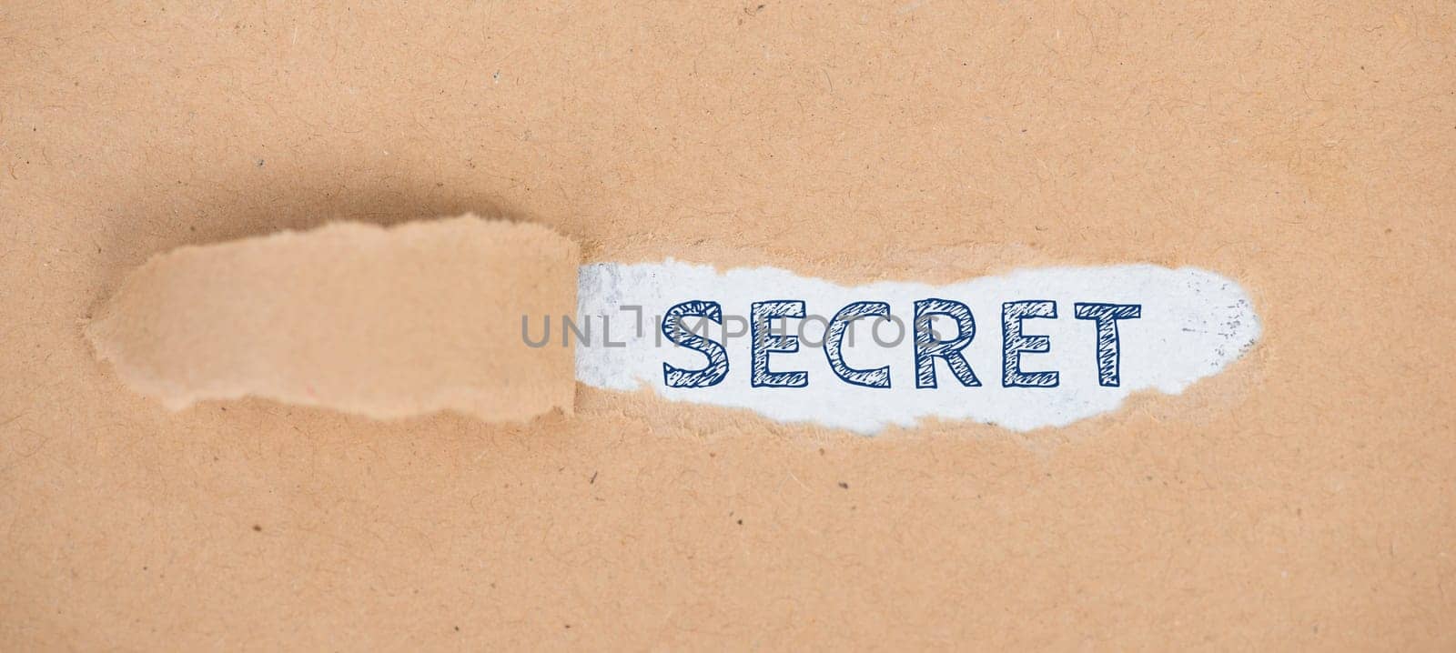 The word secret is standing on a ripped up paper