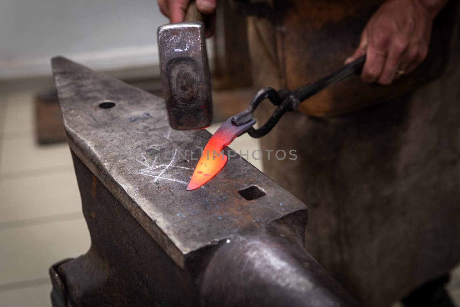 man hands are manufacturing a steel knife