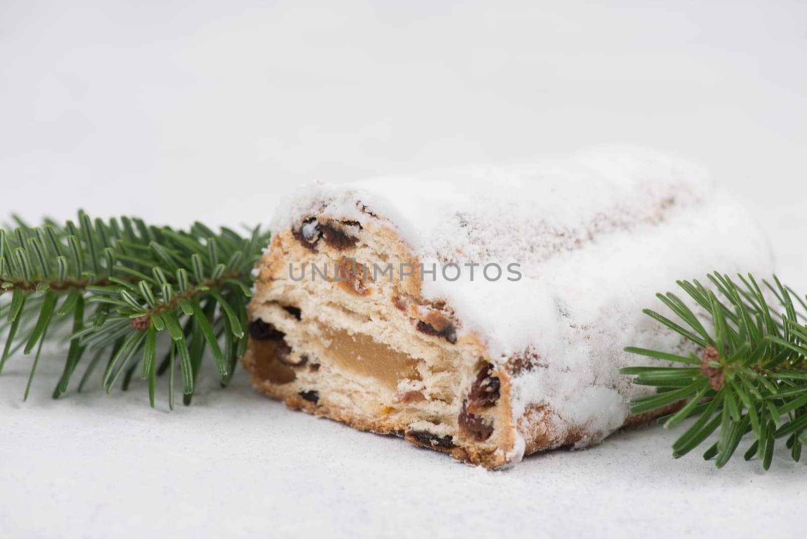 Christstollen, traditonal christmas cake with nuts, raisons, marzipan on a white background, empty space for text