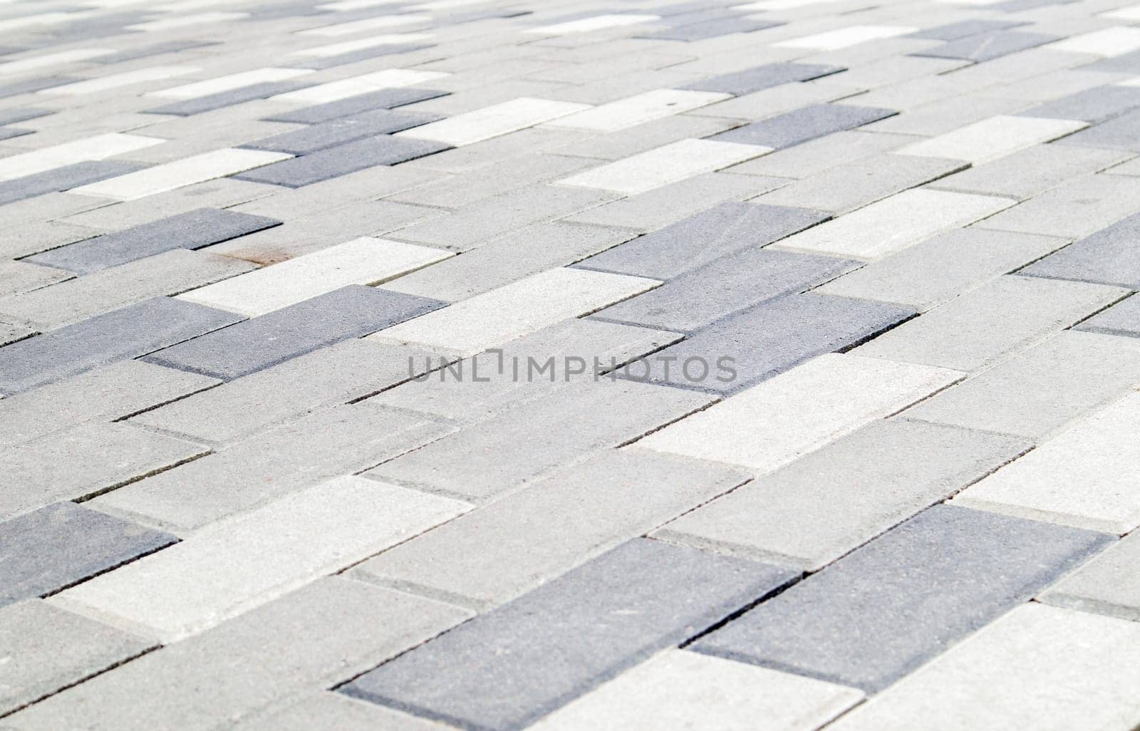 Concrete or paved newly laid gray paving slabs or stones for floors or walkways. Concrete paving slabs in the backyard or road paving. Garden brick path in the courtyard on a sandy foundation
