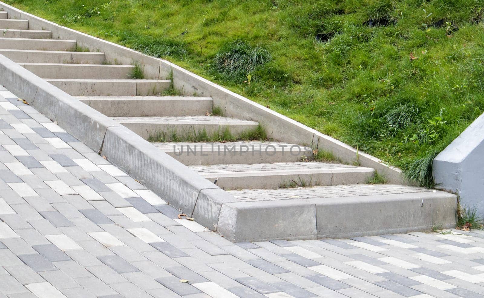 Steps from paving slabs and curbs. Rows of gray steps made of gray paving slabs are laid out evenly, consistently and tightly to each other. Paving stone steps slab gray background