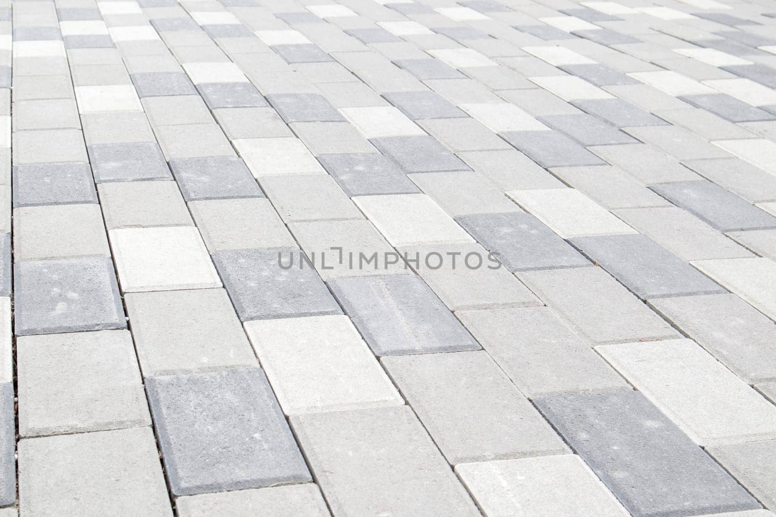 Concrete or paved newly laid gray paving slabs or stones for floors or walkways. Concrete paving slabs in the backyard or road paving. Garden brick path in the courtyard on a sandy foundation