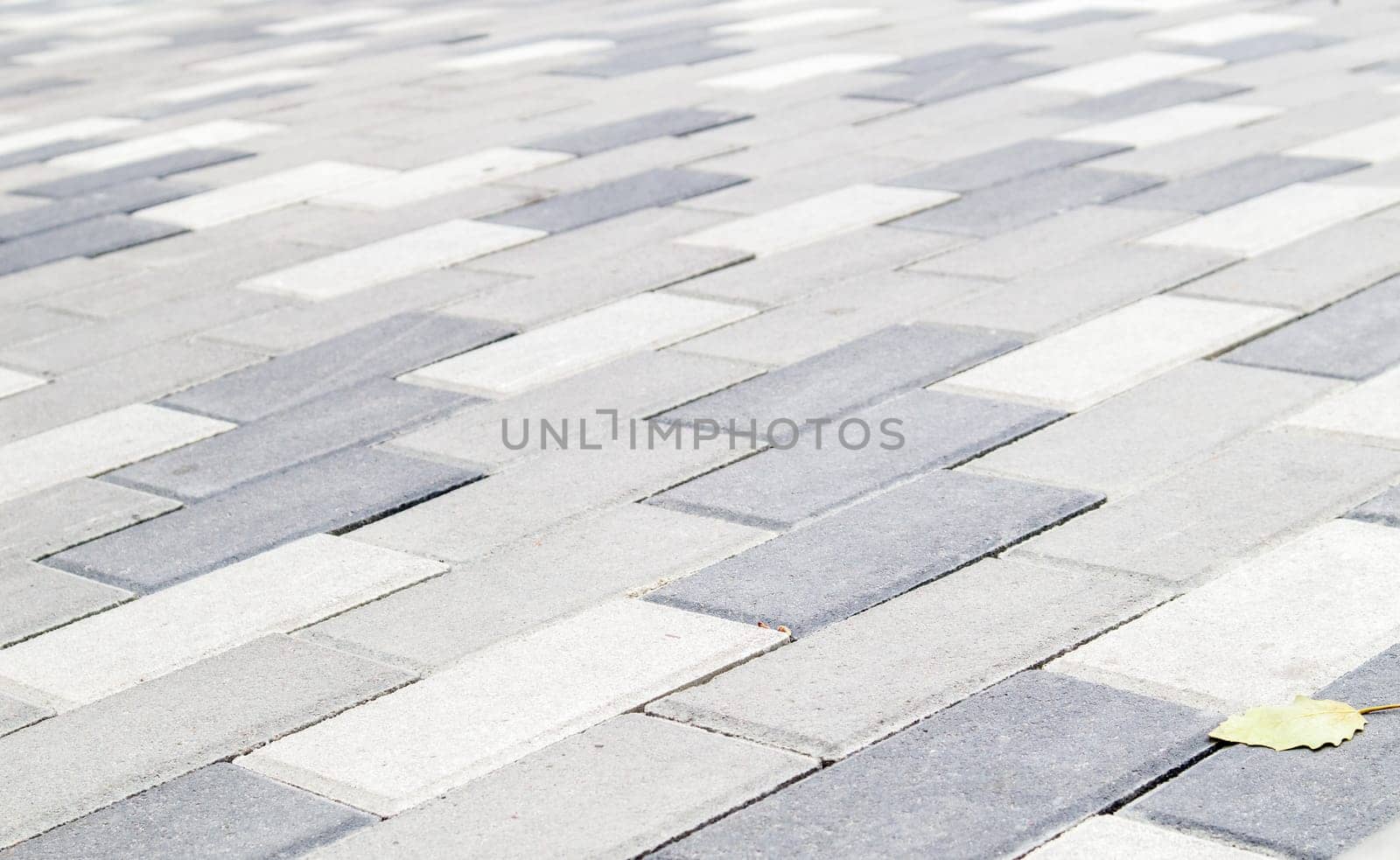 Concrete or paved newly laid gray paving slabs or stones for floors or walkways. Concrete paving slabs in the backyard or road paving. Garden brick path in the courtyard on a sandy foundation