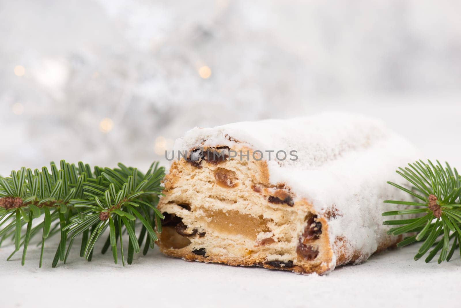 Christstollen, traditonal christmas cake with nuts, raisons, marzipan on a white background, empty space for text