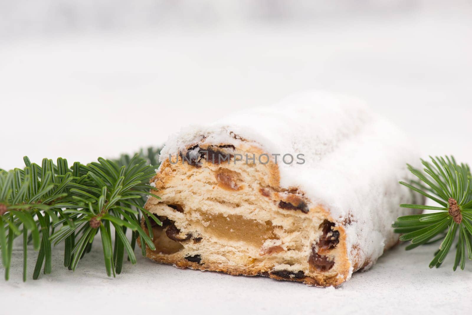 Christstollen, traditonal christmas cake with nuts, raisons, marzipan on a white background, empty space for text