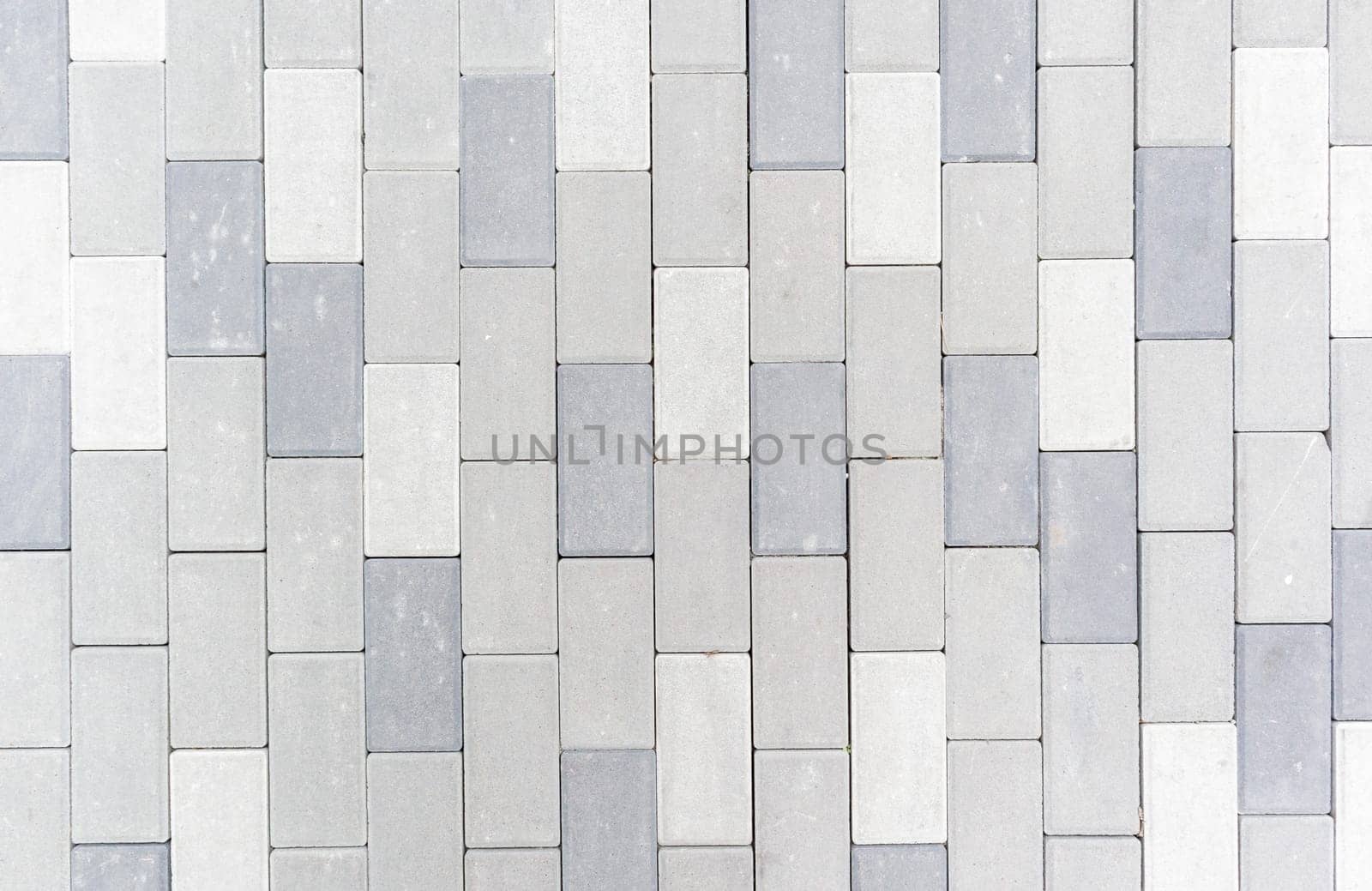 Concrete or paved newly laid gray paving slabs or stones for floors or walkways. Concrete paving slabs in the backyard or road paving. Garden brick path in the courtyard on a sandy foundation