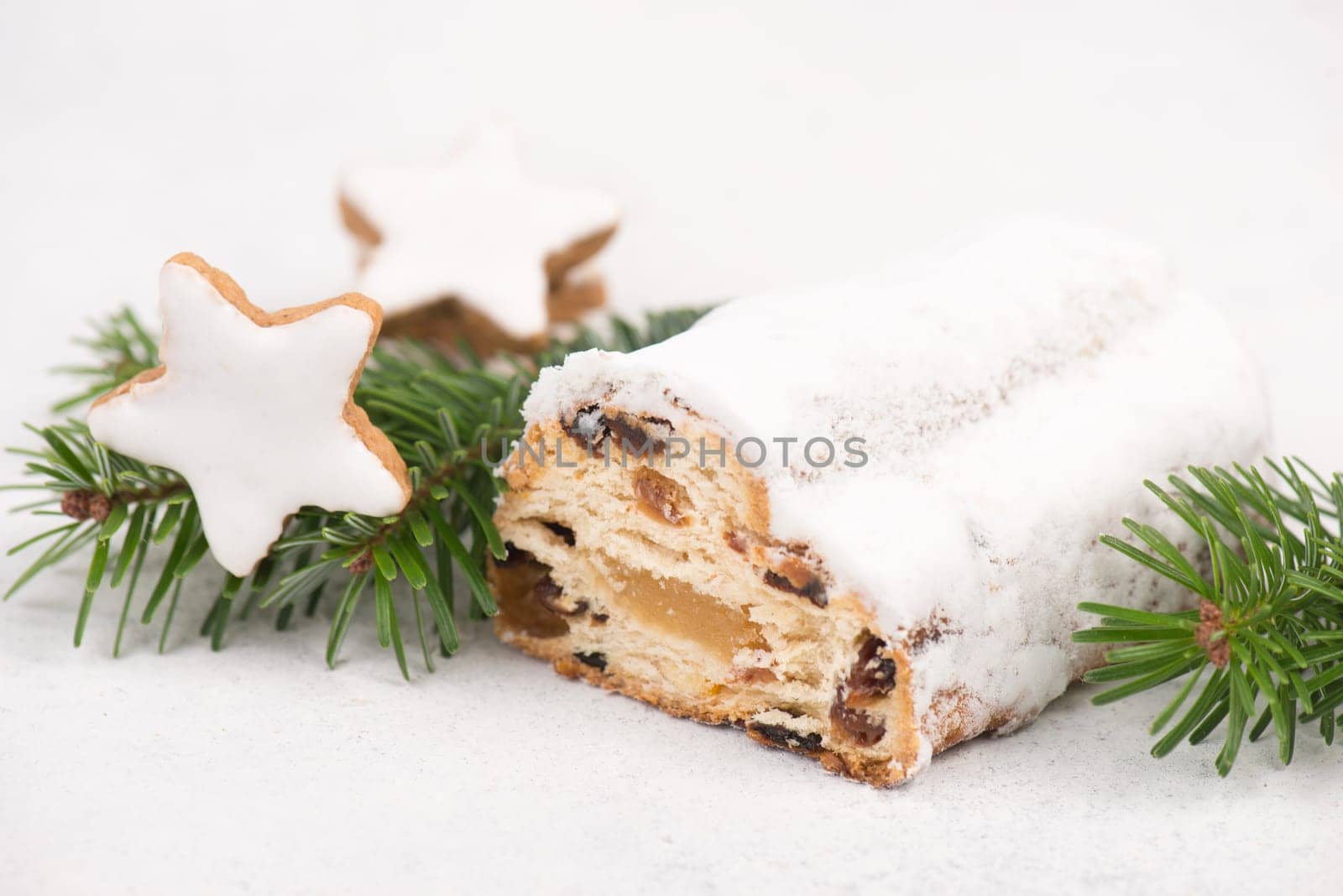 Christstollen, traditonal christmas cake with nuts, raisons, marzipan on a white background, empty space for text