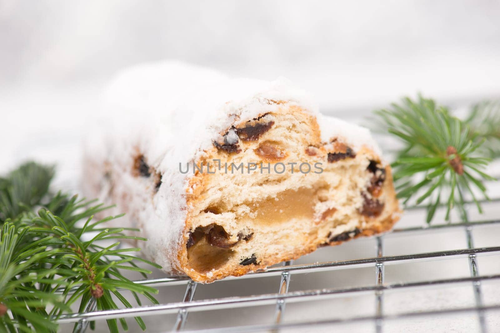Christstollen, traditonal christmas cake with nuts, raisons, marzipan on a white background, empty space for text