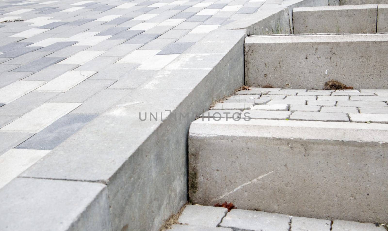 Steps from paving slabs and curbs. Rows of gray steps made of gray paving slabs are laid out evenly, consistently and tightly to each other. Paving stone steps slab gray background