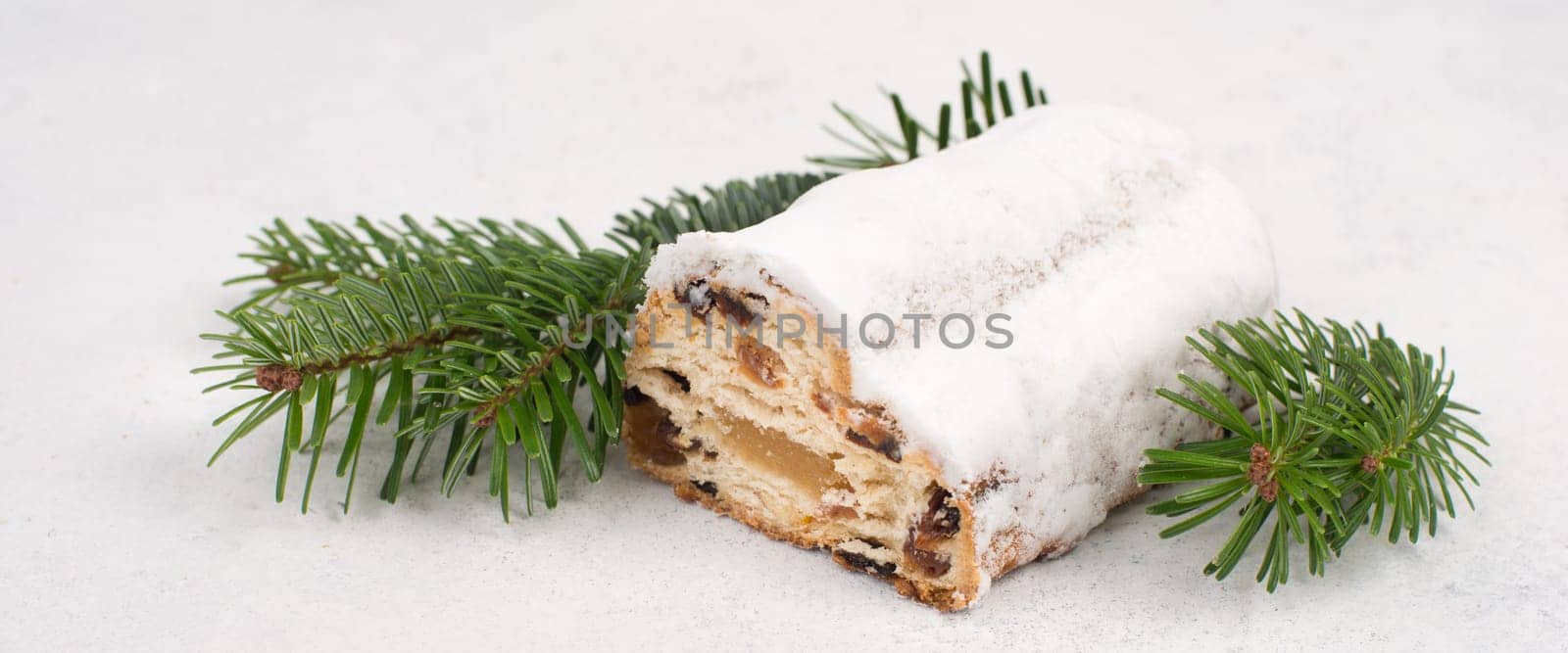 Christstollen, traditonal christmas cake with nuts, raisons, marzipan on a white background, empty space for text