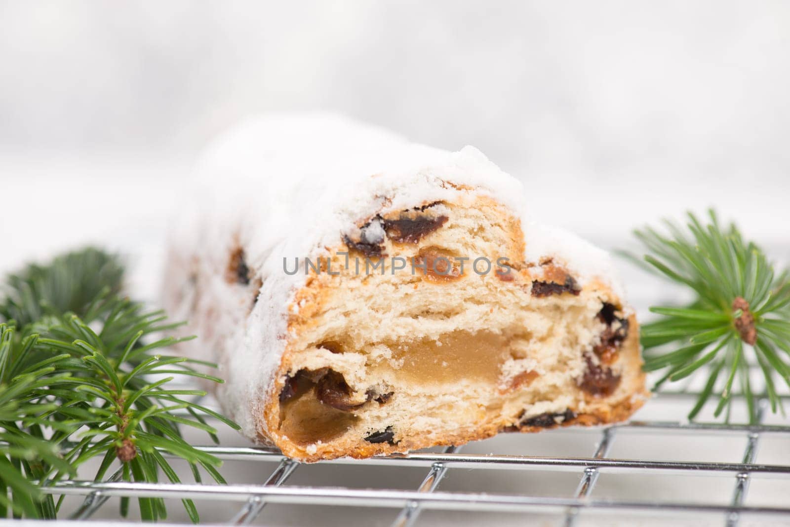 Christstollen, traditonal christmas cake with nuts, raisons, marzipan on a white background, empty space for text