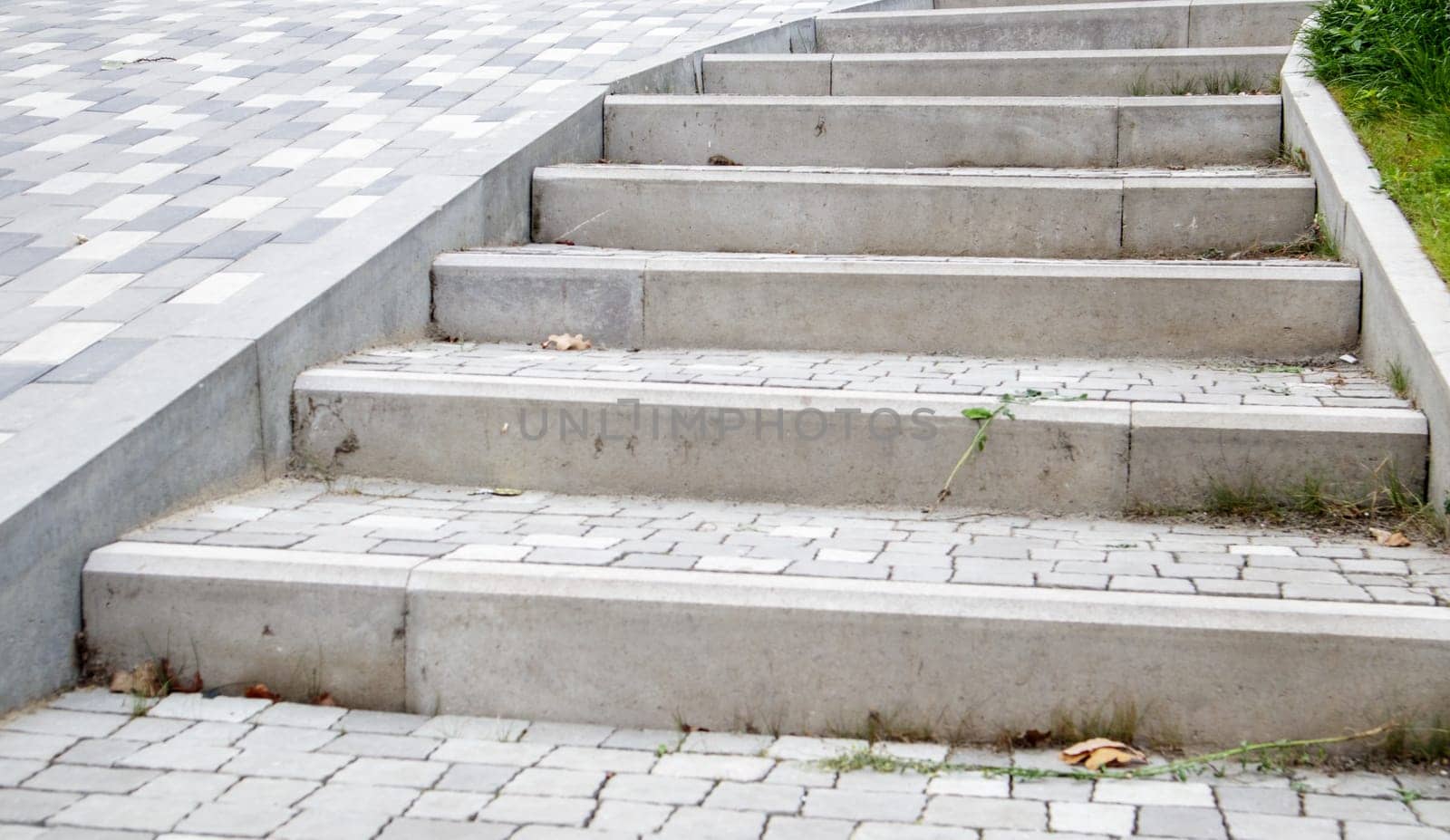 Steps from paving slabs and curbs. Rows of gray steps made of gray paving slabs are laid out evenly, consistently and tightly to each other. Paving stone steps slab gray background