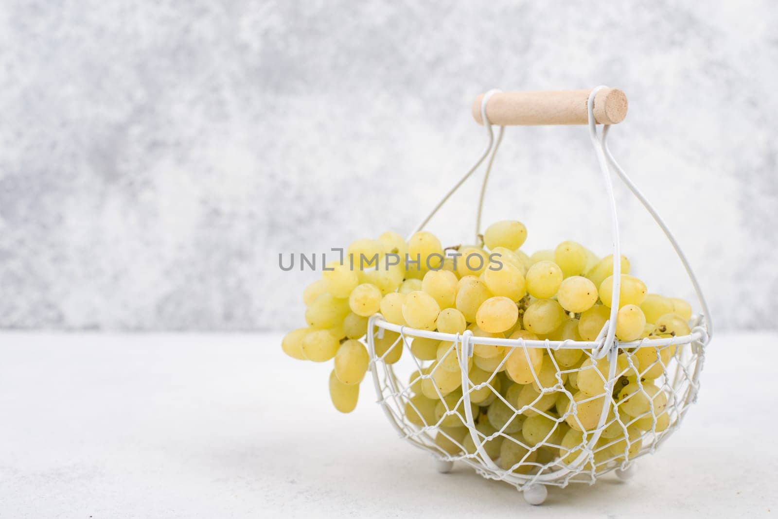 Grapes in a basket on a textured background, empty space for text