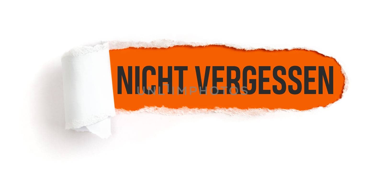 Hole in white paper with torns edges - Important in german - Nicht vergessen