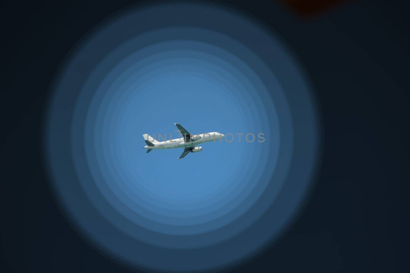 Plane flying high in sky. View to air liner flying in blue sky. Airplane seen in blue sky. Aerial panorama with aircraft in cloudless sky. Flying air liner