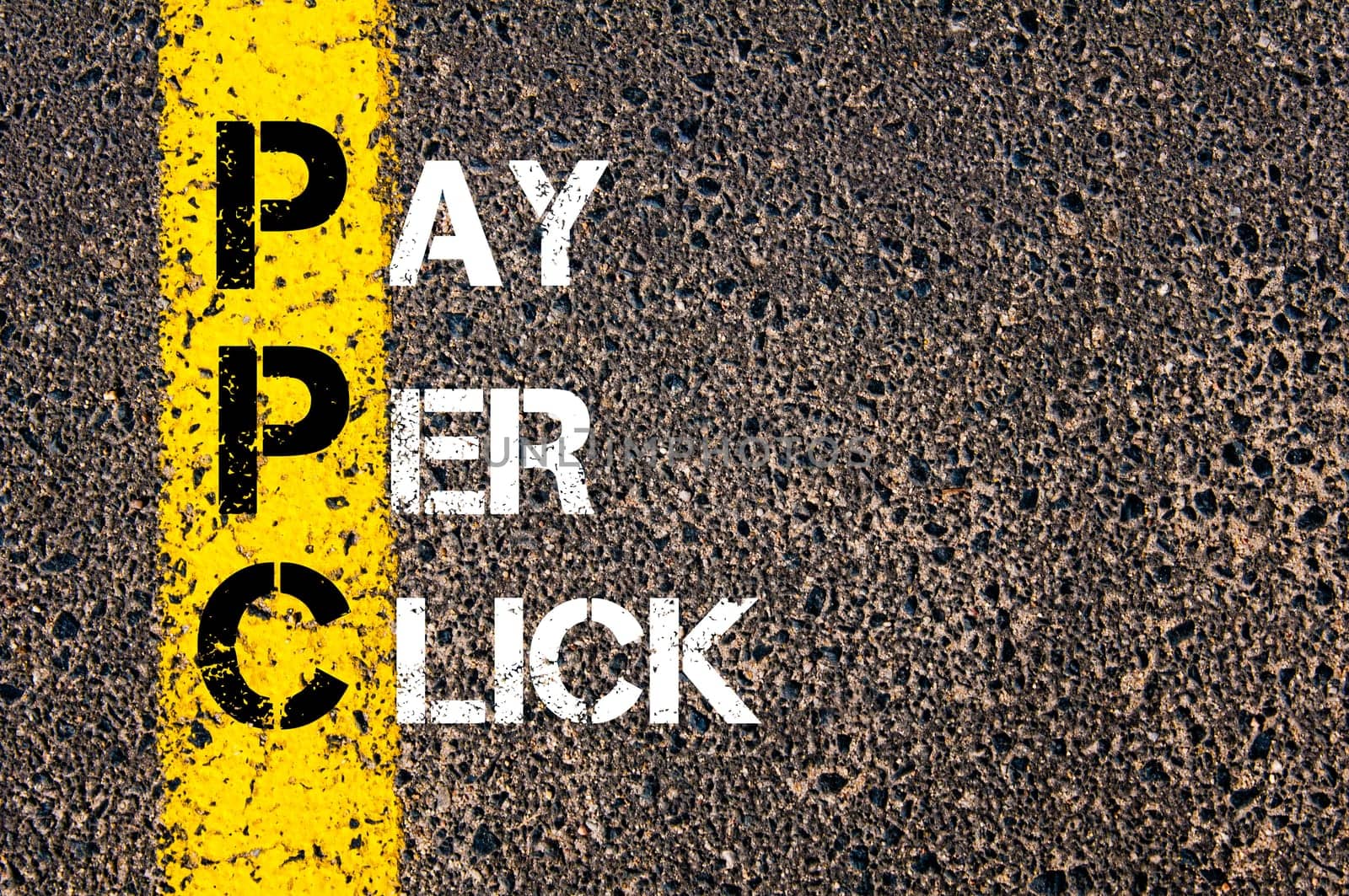 Acronym PPC - Pay Per Click. Business Conceptual image with yellow paint line on the road over asphalt stone background.