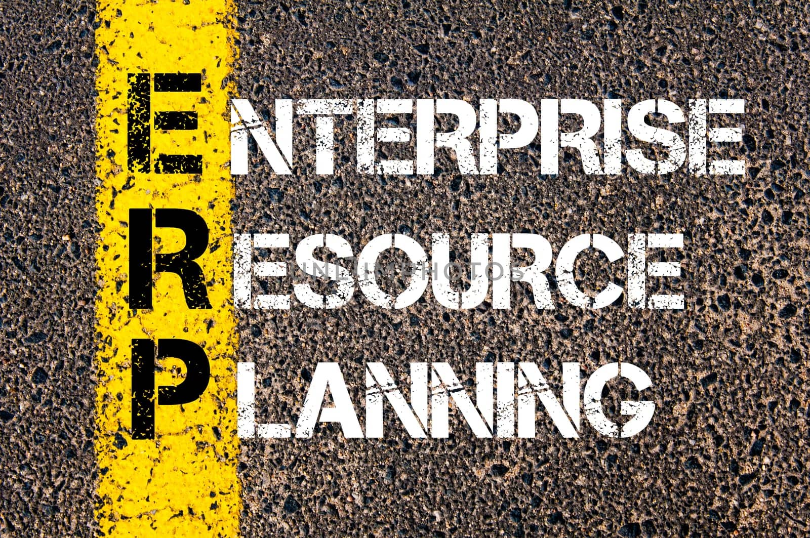 Acronym ERP - Enterprise Resource Planning. Business Conceptual image with yellow paint line on the road over asphalt stone background.