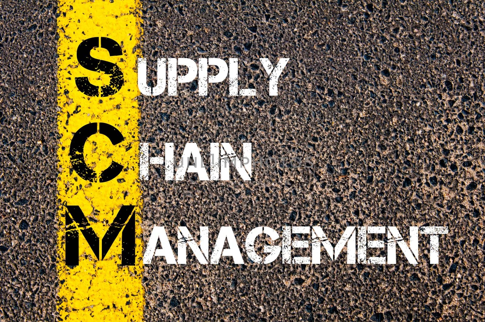 Acronym SCM- Supply Chain Management. Business Conceptual image with yellow paint line on the road over asphalt stone background.