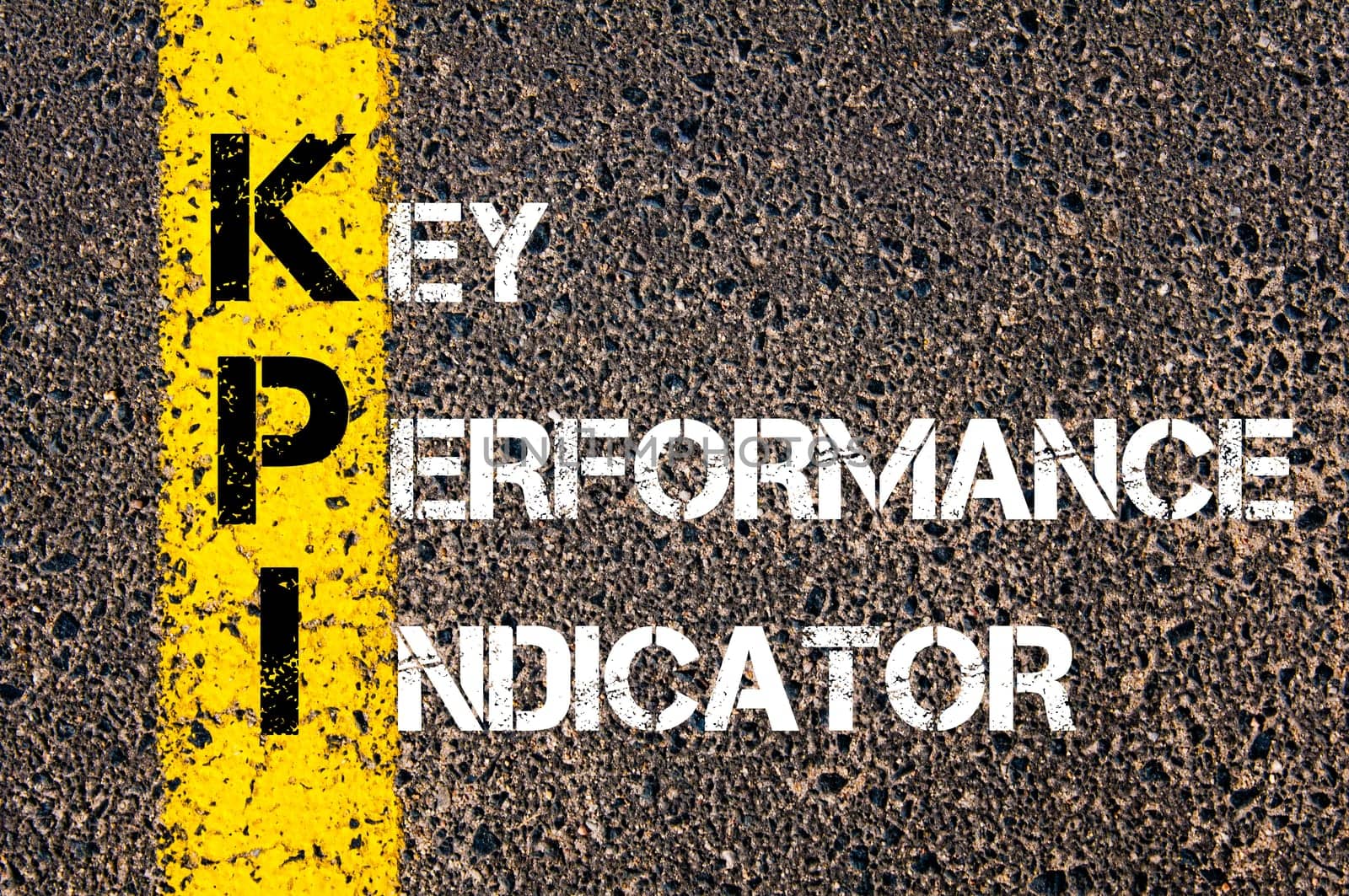Acronym KPI - Key Performance Indicator. Business Conceptual image with yellow paint line on the road over asphalt stone background.