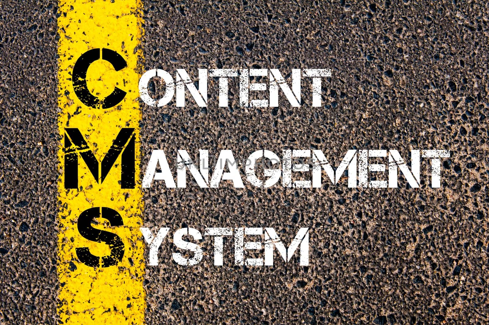 Acronym CMS - Content Management System. Business Conceptual image with yellow paint line on the road over asphalt stone background.
