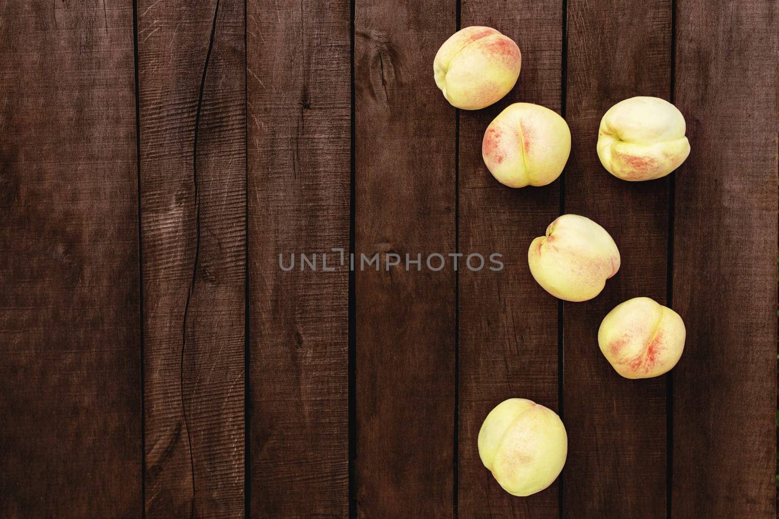 Flat lay with large and big juicy organic peaches group on the brown wooden table background with old boards. Natural fruits, copy space area. High quality photo