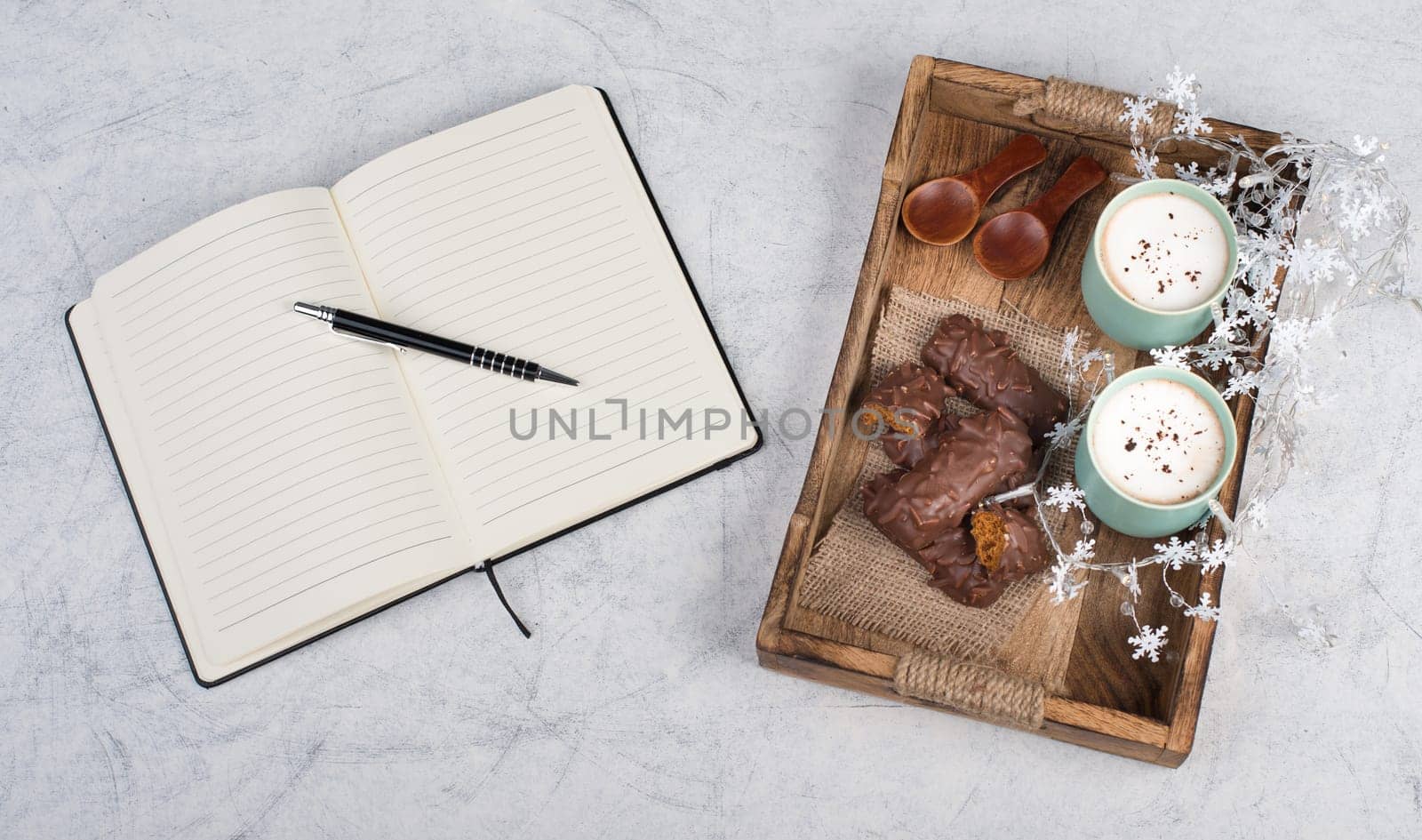 Coffee cups and chocolate coated gingerbread in a wooden basket, empty copy space, christmas season