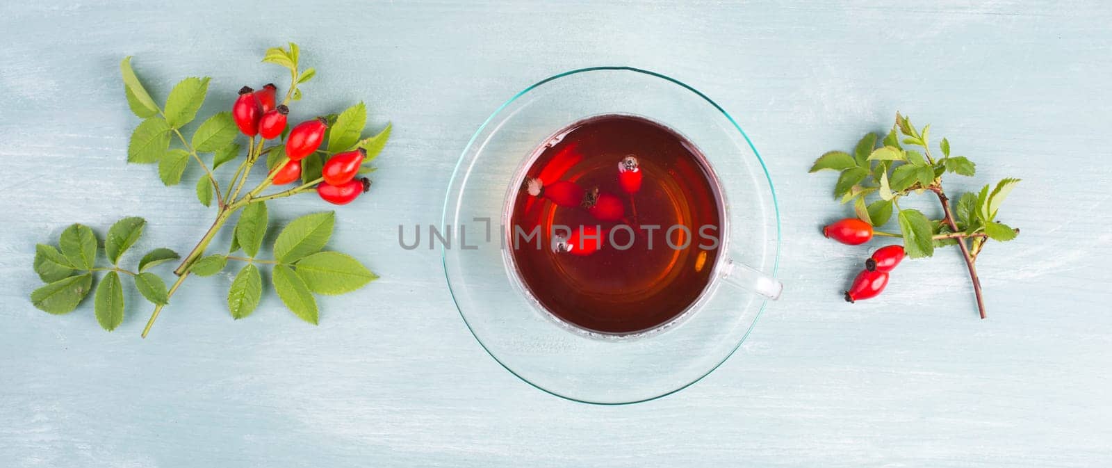 Hip rose tea with fresh fruits and leaves, hot drink