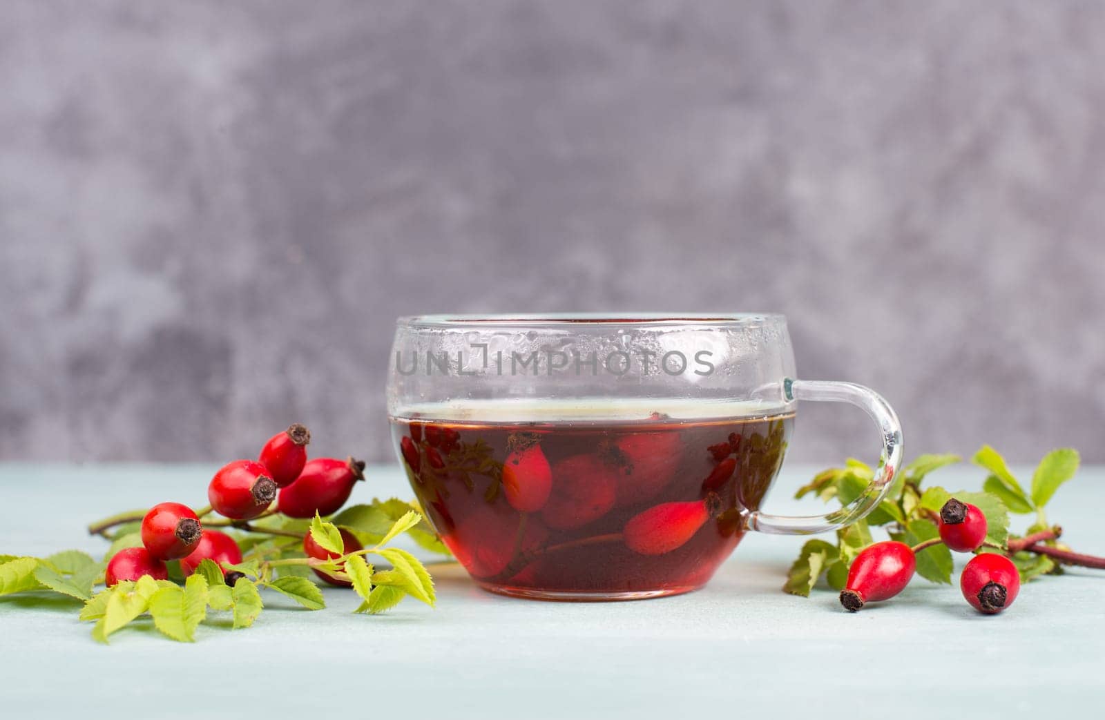 Hip rose tea with fresh fruits and leaves, hot drink