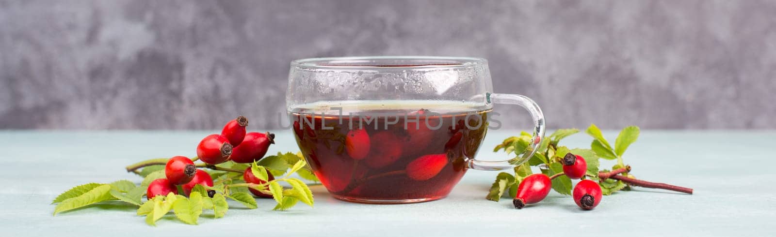 Hip rose tea with fresh fruits and leaves, hot drink