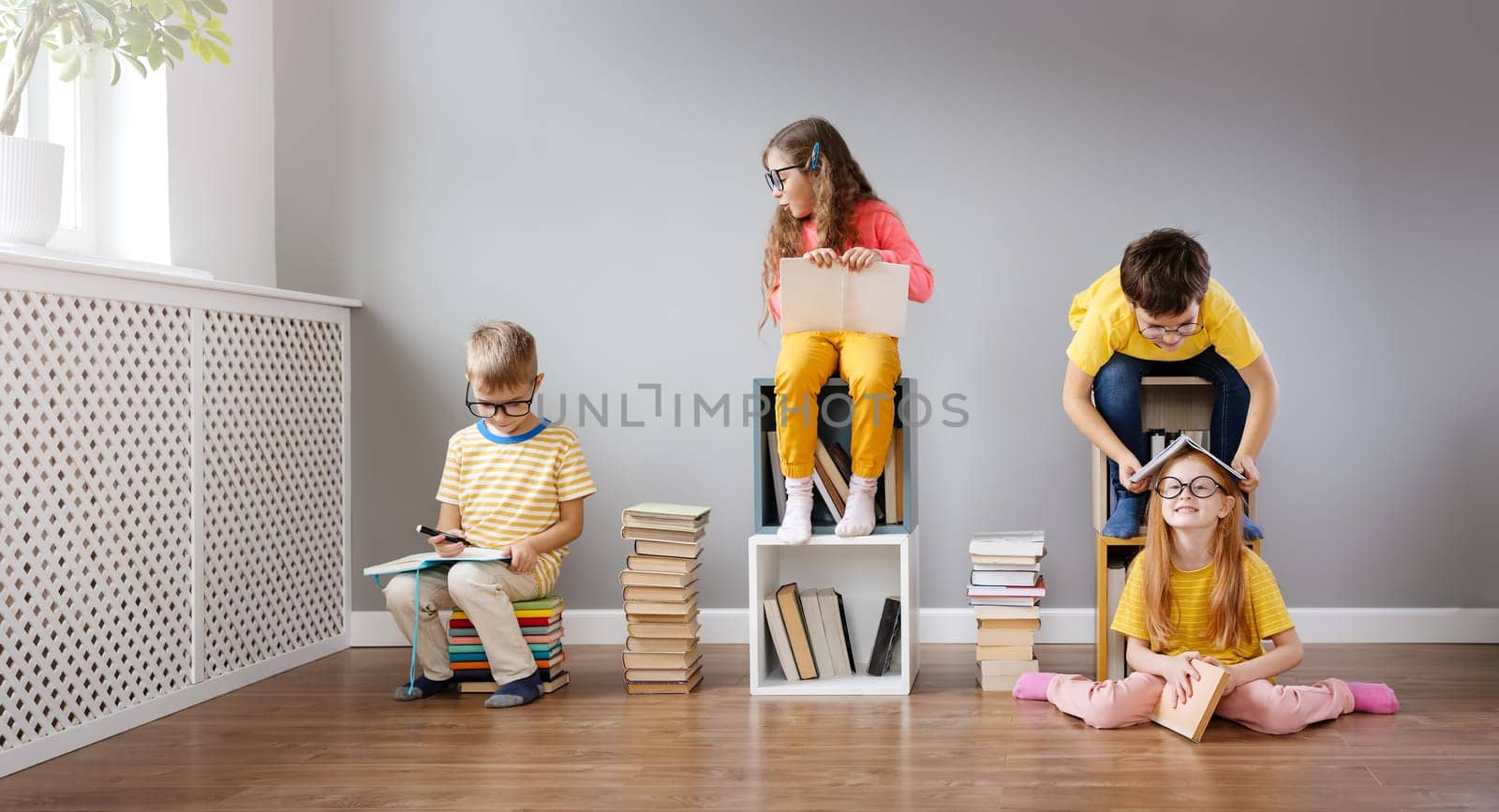 Group of children sitting in the room and reading books. Concept of education and friendship.